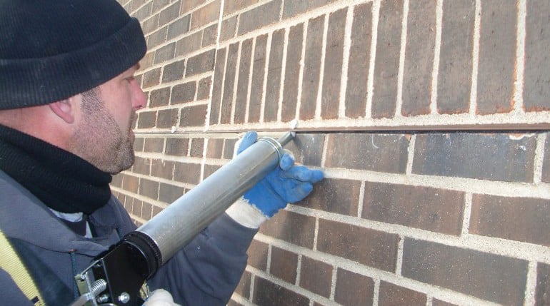 brc-sealant-replacement worker replacing sealant and caulking