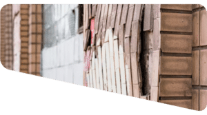 Misaligned and bulging exterior brick cladding showing structural movement.