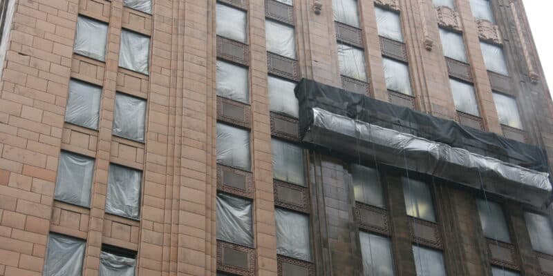 Facade cleaning in progress at the Baker Center Building, showing a contrast between cleaned and uncleaned sections.