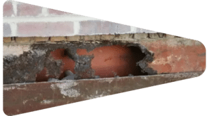 Severely corroded steel lintel beneath a brick facade.